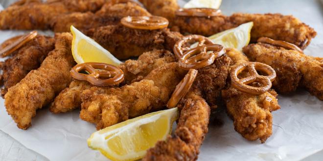 a plate of baked chicken breaded with pretzels