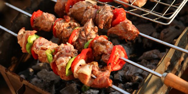 shish kebabs and chicken legs over a charcoal grill