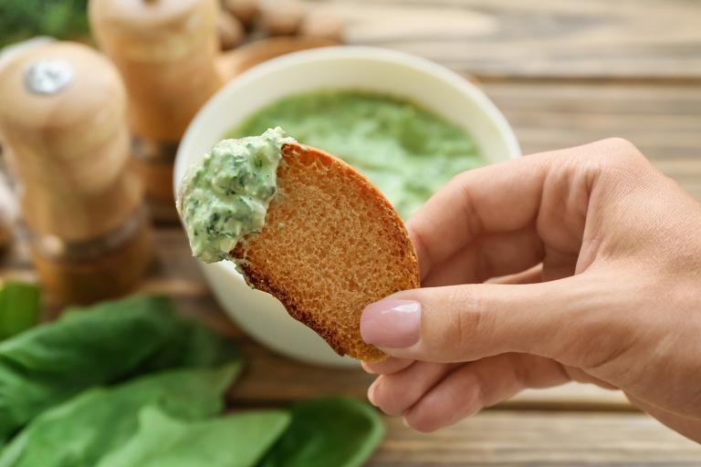 Healthier Spinach-Cheese Dip toasted bread dipped into spinach-cheese dip