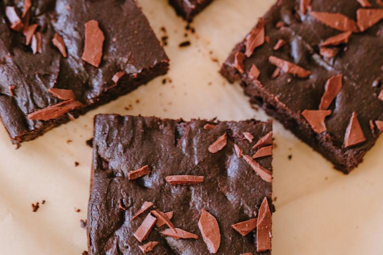 Double Chocolate Brownies freshly baked brownies cut into squares on parchment paper.