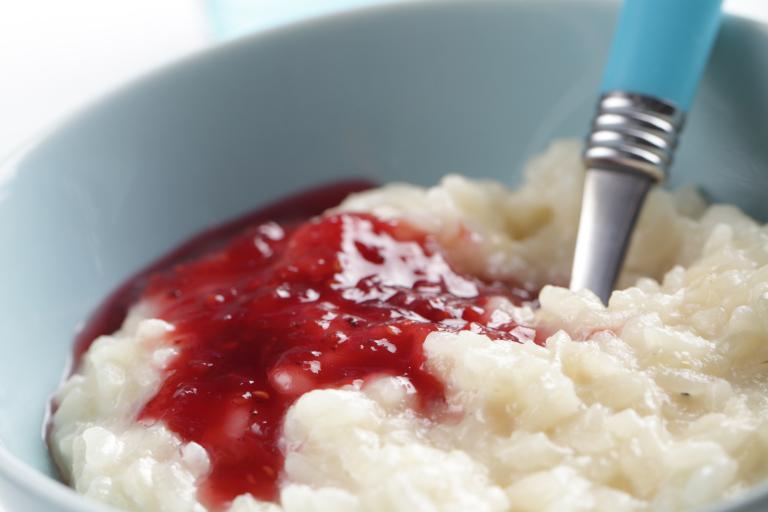 Ginger Rice Pudding a bowl of rice pudding drizzled with a berry sauce