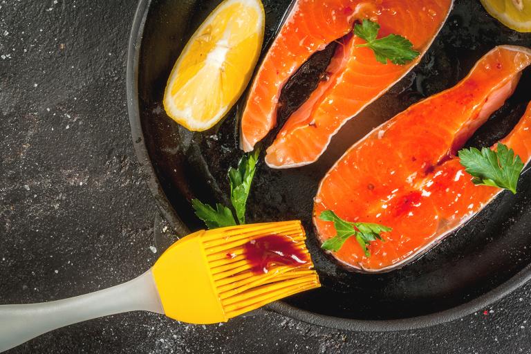 3 Sauces for Grilled Salmon salmon being slathered with sauce for the grill