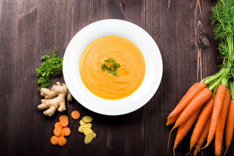 a bowl of carrot and ginger soup with garlic