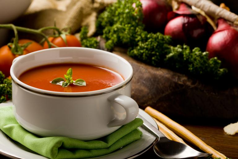 Turmeric Tomato Detox Soup a bowl of soup surrounded by fresh vegetables